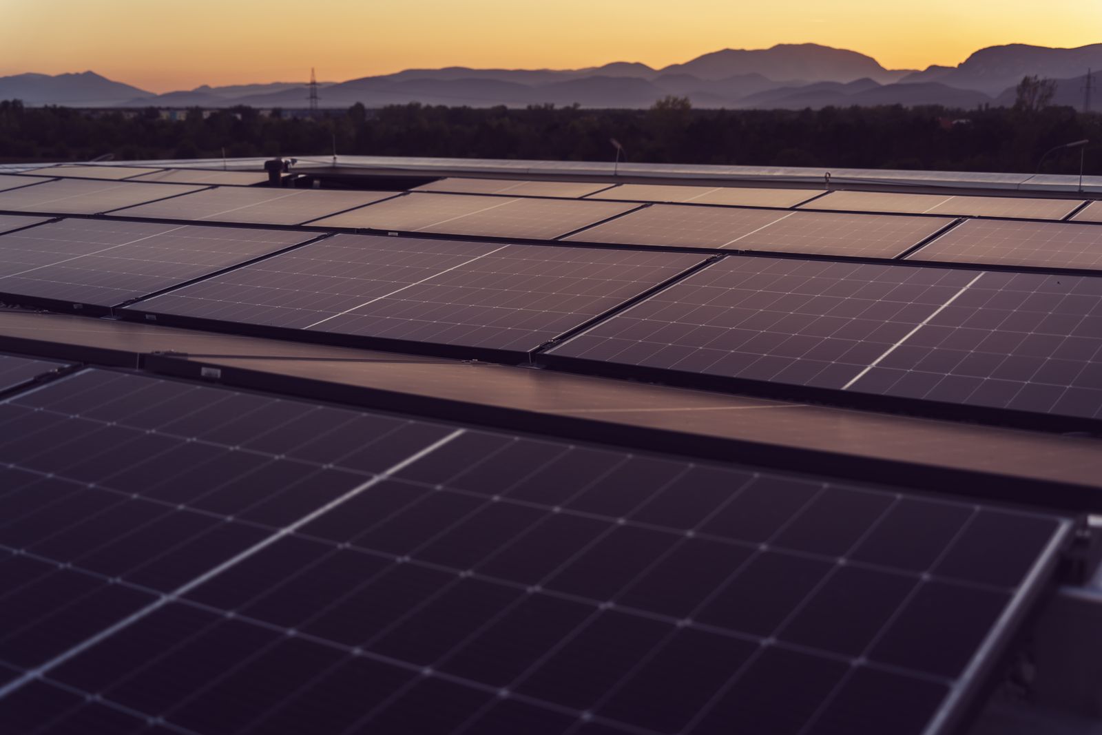 Industrial rooftop solar array at sunset